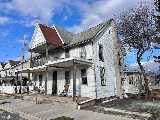 view of front of property with a porch and a balcony