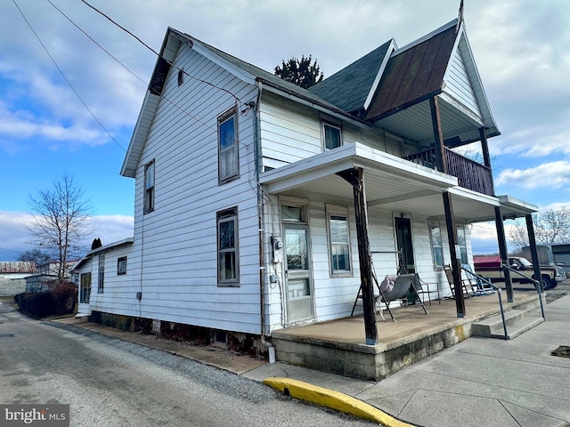 view of front of property featuring a porch and a balcony