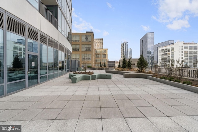 view of home's community featuring a view of city, fence, and a patio