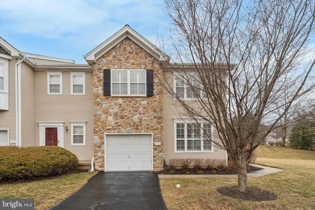 view of front of property with stone siding, a front lawn, and aphalt driveway