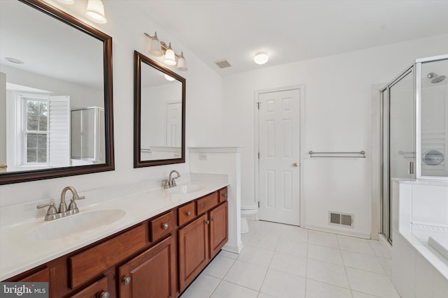 bathroom with a stall shower, tile patterned floors, a sink, and double vanity