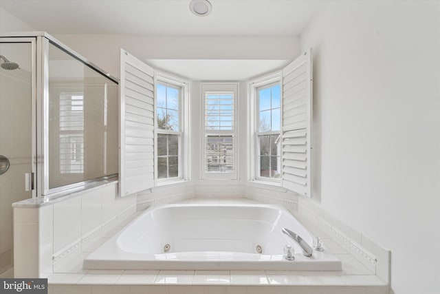 bathroom featuring a jetted tub and a shower stall