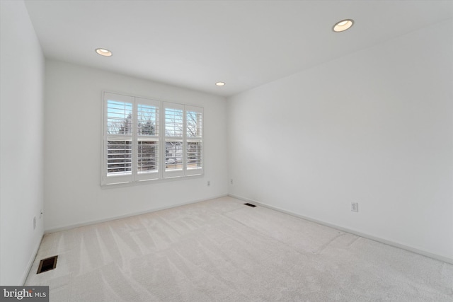 spare room with carpet floors, visible vents, baseboards, and recessed lighting