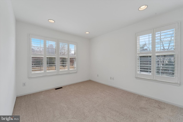 carpeted spare room with recessed lighting, visible vents, and baseboards