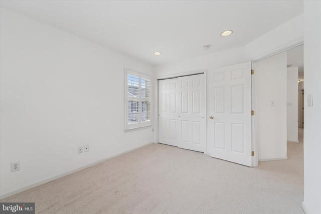 unfurnished bedroom featuring carpet floors, baseboards, a closet, and recessed lighting