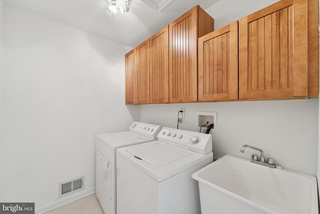 clothes washing area featuring cabinet space, visible vents, separate washer and dryer, and a sink