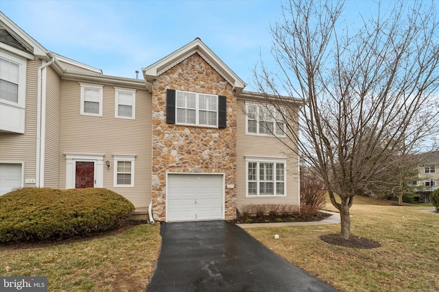 view of front of property featuring a garage, stone siding, aphalt driveway, and a front yard