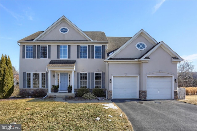 view of front facade with aphalt driveway, stone siding, a front lawn, and a garage