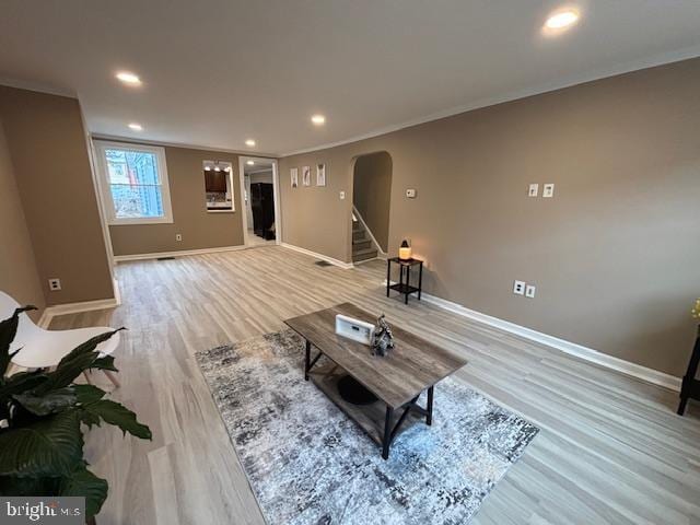 living room featuring ornamental molding and light hardwood / wood-style floors