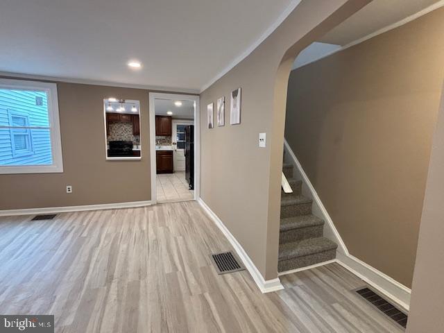 interior space with ornamental molding and light hardwood / wood-style flooring