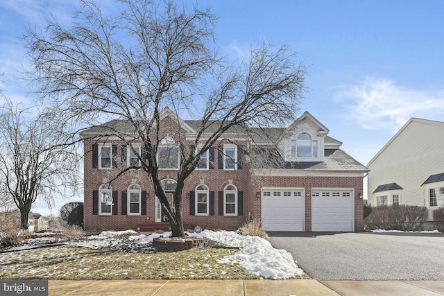 view of front facade with driveway, an attached garage, and brick siding