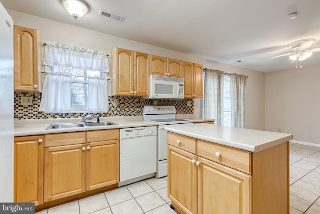 kitchen featuring sink, white appliances, a healthy amount of sunlight, and backsplash