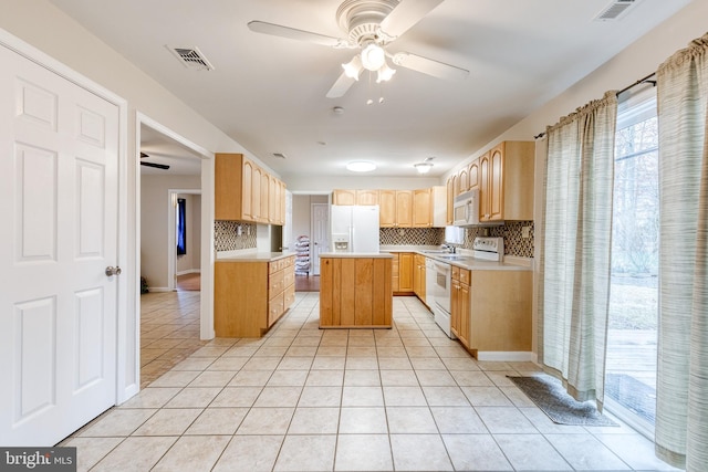 kitchen with white appliances, a center island, light tile patterned floors, ceiling fan, and decorative backsplash