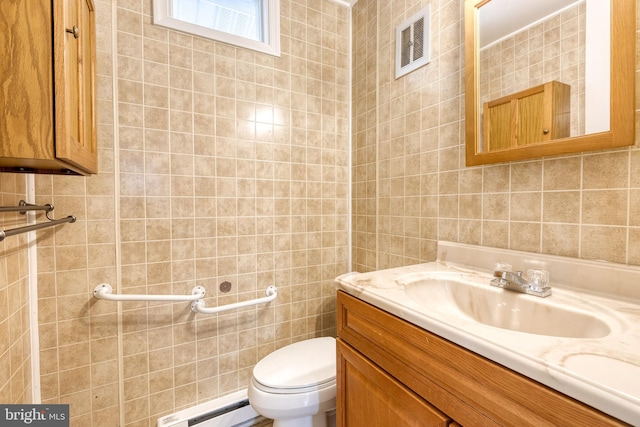 bathroom with vanity, tile walls, baseboard heating, and toilet