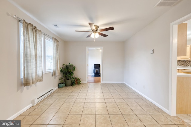 empty room featuring light tile patterned flooring, ceiling fan, and baseboard heating