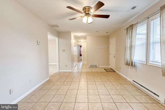 spare room featuring ceiling fan, light tile patterned floors, and a baseboard heating unit