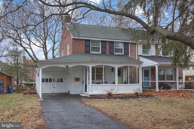 view of front of home with a porch, a garage, and a front yard