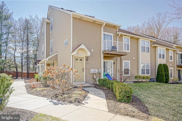 multi unit property featuring a front yard and fence