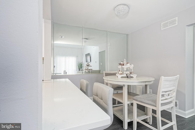 dining space featuring baseboards, visible vents, and dark wood-type flooring