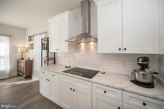 kitchen featuring white cabinets, light stone countertops, dark wood-type flooring, black electric cooktop, and wall chimney exhaust hood