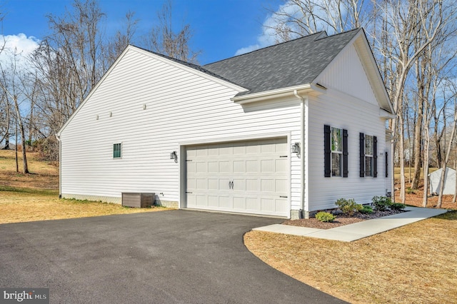 view of property exterior with central AC and a garage