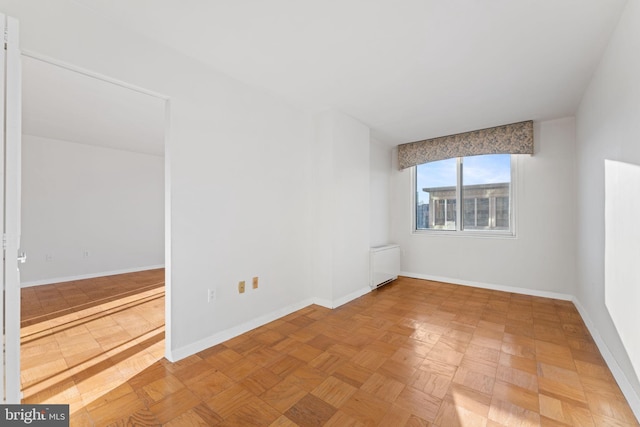 spare room with parquet floors and radiator