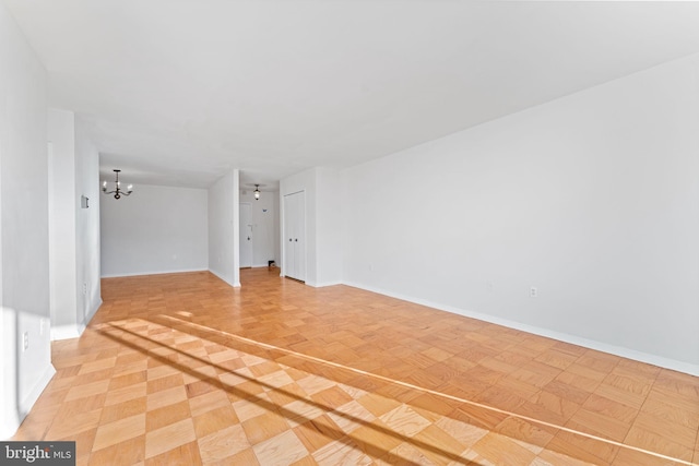 unfurnished room featuring light parquet floors and a chandelier