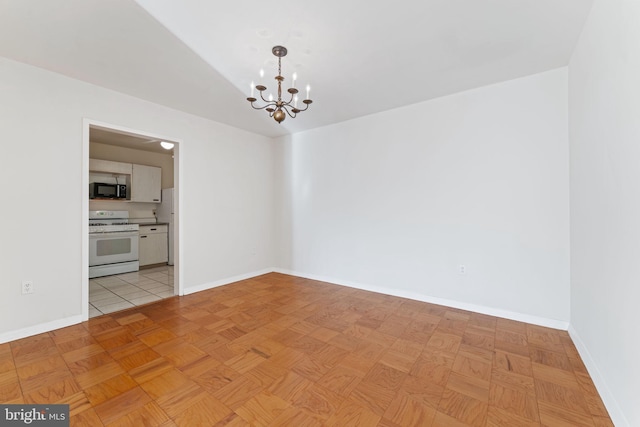 unfurnished room with light parquet flooring and a chandelier