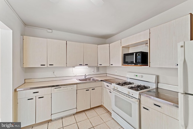 kitchen featuring sink, light tile patterned floors, and white appliances