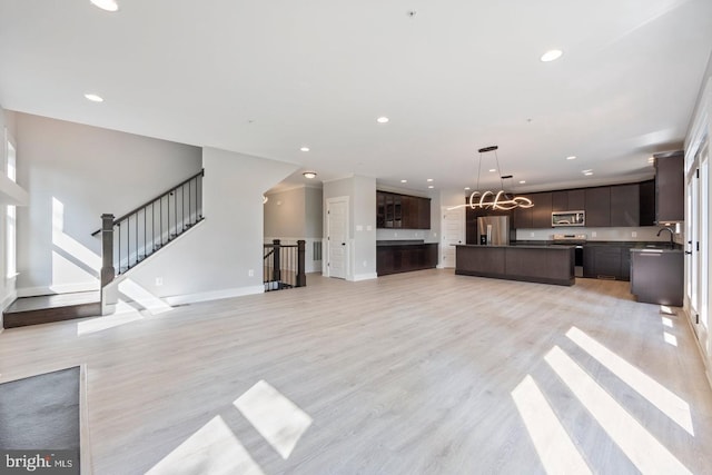 unfurnished living room featuring sink and light wood-type flooring