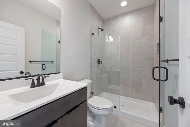 bathroom with vanity, toilet, and a shower with shower door