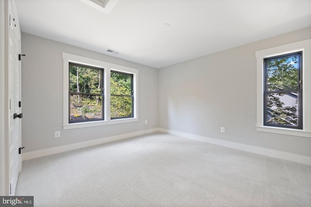 unfurnished room with a wealth of natural light and light colored carpet