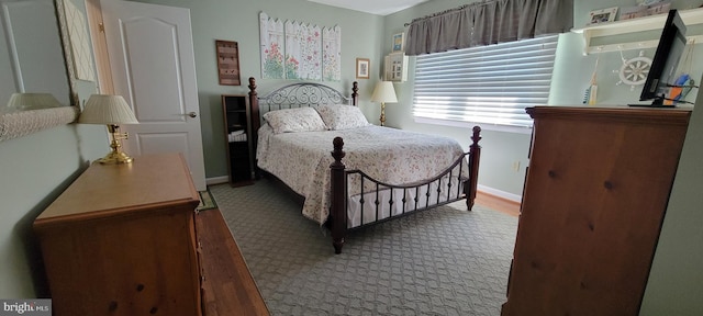 bedroom featuring wood finished floors and baseboards