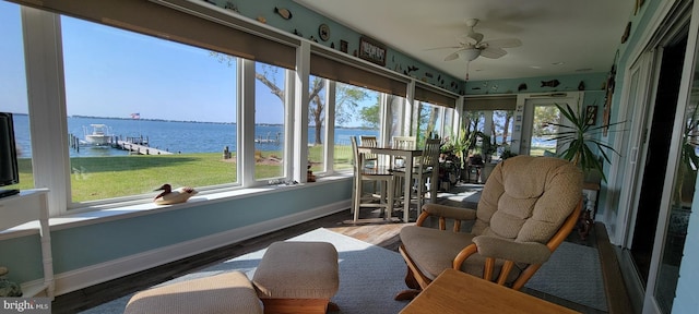 sunroom / solarium featuring a water view and ceiling fan