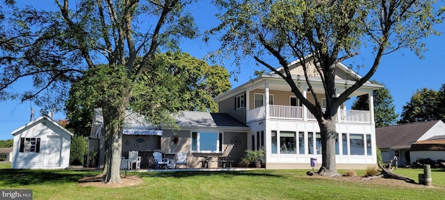 back of property with a yard and a balcony