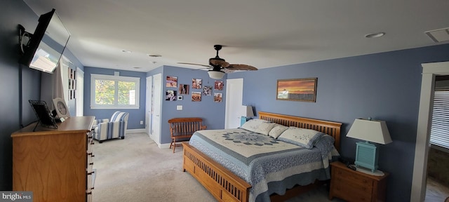 bedroom with light carpet, ceiling fan, visible vents, and baseboards