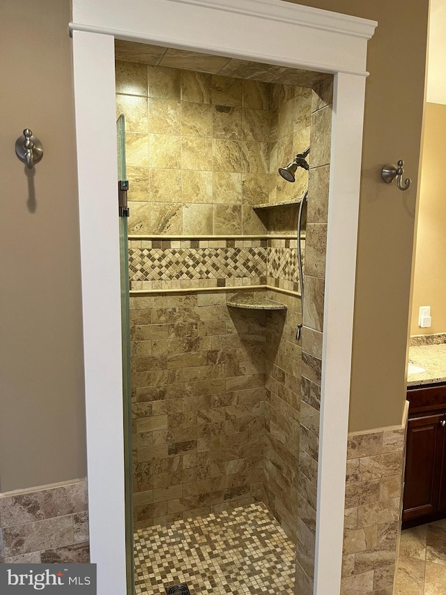 full bath with a stall shower and vanity