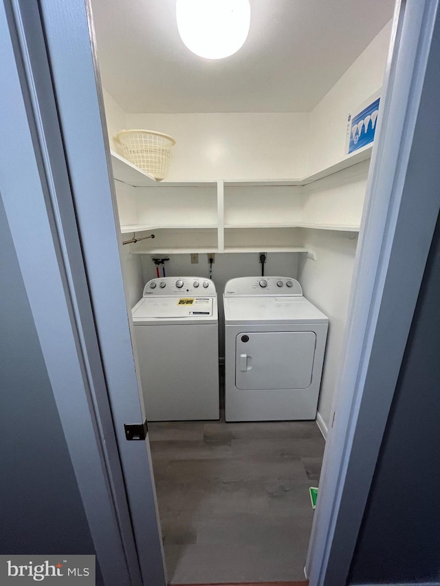 washroom with laundry area, separate washer and dryer, and wood finished floors