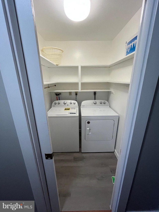 clothes washing area with laundry area, independent washer and dryer, and wood finished floors