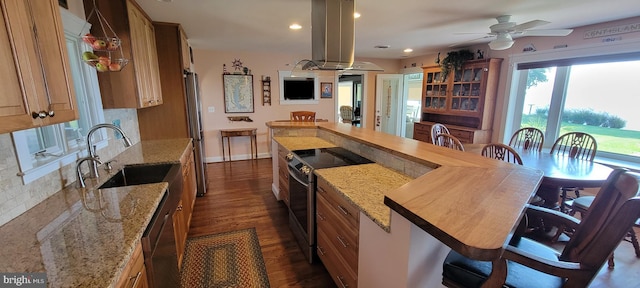 kitchen featuring dark wood-style floors, brown cabinets, island exhaust hood, stainless steel appliances, and a sink