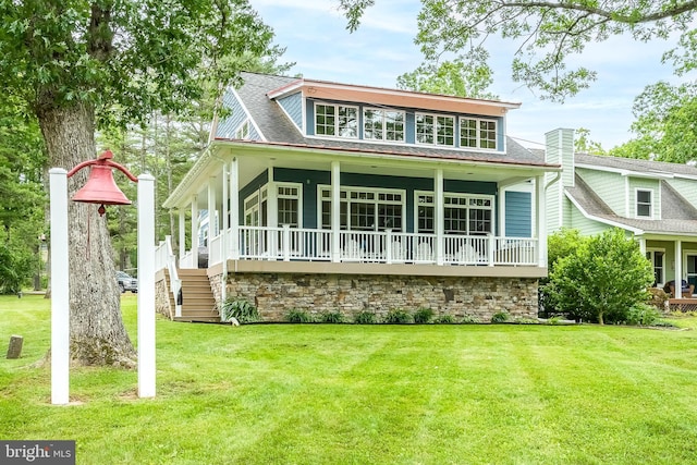 rear view of house with a porch, a lawn, a chimney, and a shingled roof