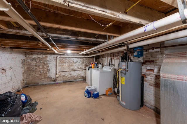 basement featuring water heater and washer and clothes dryer