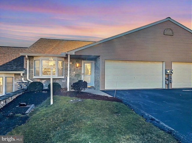 view of front facade with a garage and a lawn