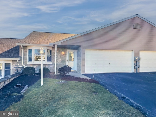 ranch-style house with a garage and a front lawn