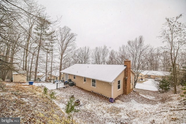 snow covered property featuring a chimney