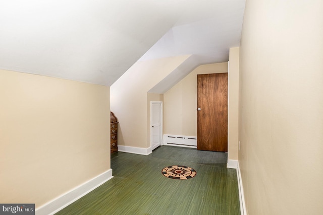 additional living space featuring vaulted ceiling, baseboards, and baseboard heating