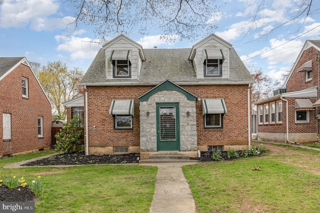 cape cod house with brick siding, entry steps, a shingled roof, and a front lawn