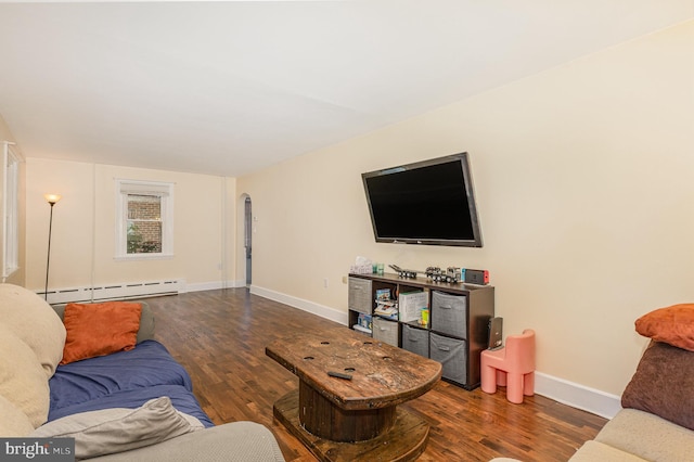 living area with baseboards, baseboard heating, wood finished floors, and arched walkways