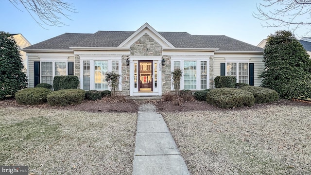 view of front of property featuring stone siding and a shingled roof