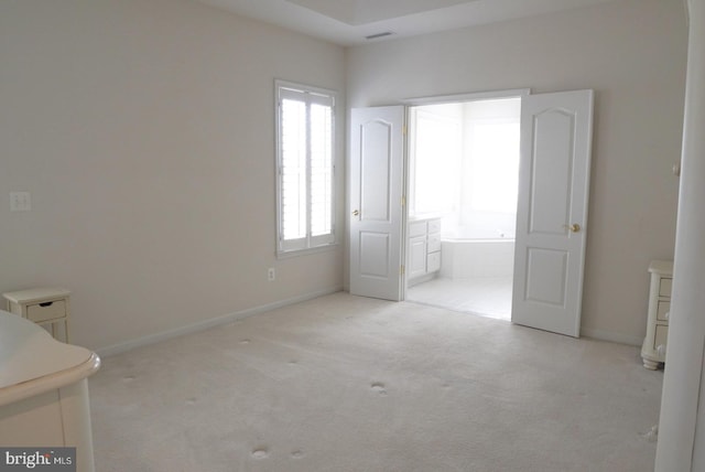 unfurnished bedroom featuring carpet floors, visible vents, connected bathroom, and baseboards